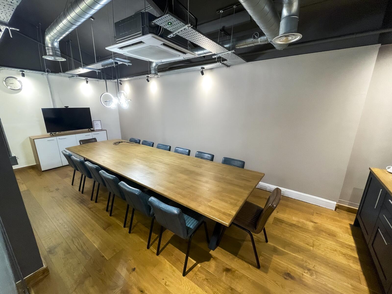 Angled wide view of modern meeting room with seating and presentation area