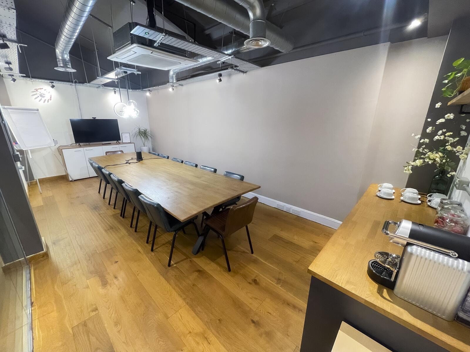 Full-room perspective of The Orbit, highlighting its spacious layout, presentation area and seating for larger team sessions.